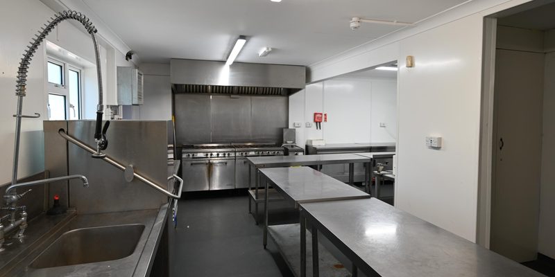 The commercial kitchen with stainless steel worktops